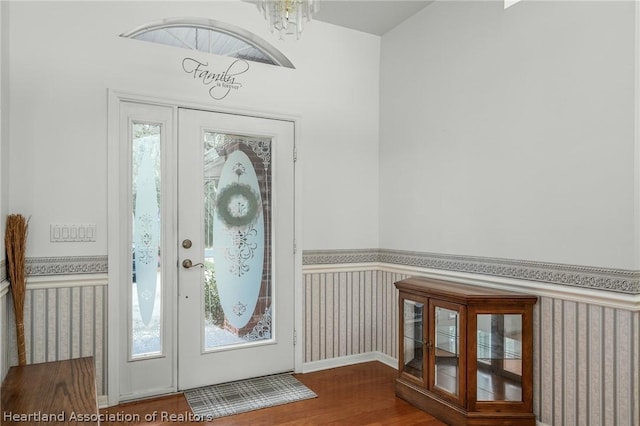 entrance foyer with a healthy amount of sunlight, wood-type flooring, and an inviting chandelier