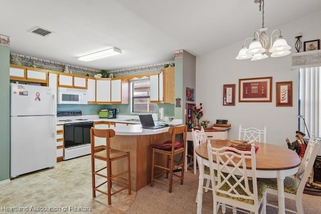 kitchen with white appliances, visible vents, a peninsula, light countertops, and a chandelier