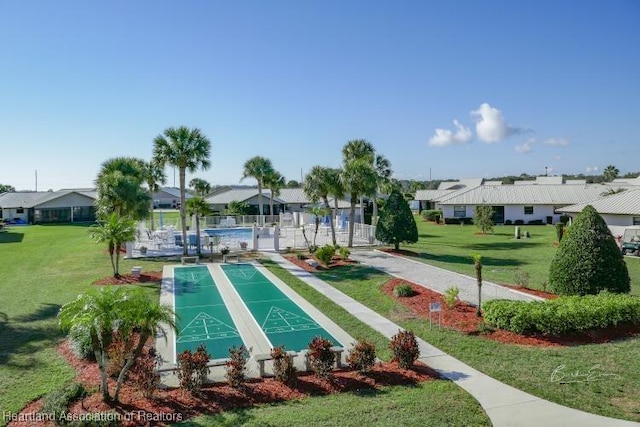 view of property's community featuring a residential view, shuffleboard, and a yard