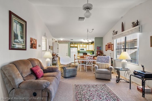 living room featuring lofted ceiling, visible vents, and an inviting chandelier