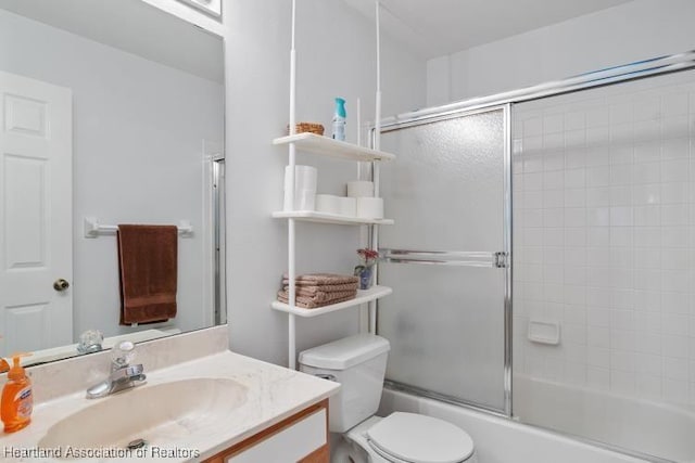 bathroom with shower / bath combination with glass door, vanity, and toilet