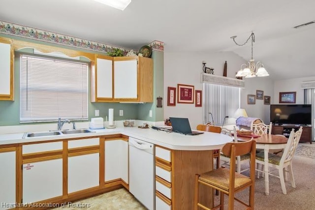 kitchen with light countertops, a sink, a chandelier, dishwasher, and a peninsula