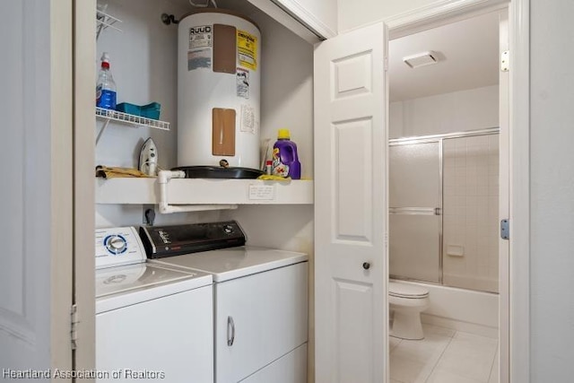 laundry area with laundry area, electric water heater, independent washer and dryer, and tile patterned floors