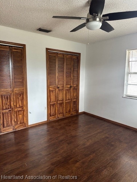 unfurnished bedroom featuring ceiling fan, dark hardwood / wood-style floors, and a textured ceiling