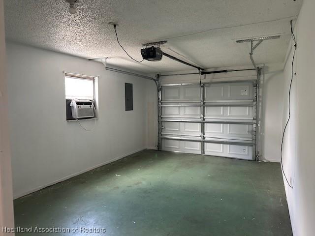 garage featuring electric panel, cooling unit, and a garage door opener