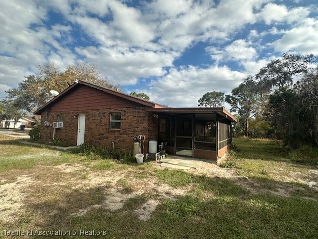 rear view of house with a sunroom and a yard