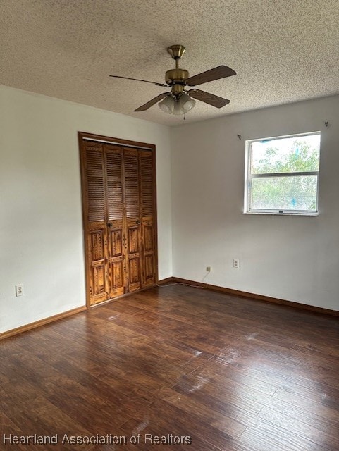 unfurnished bedroom featuring a textured ceiling, ceiling fan, a closet, and dark hardwood / wood-style floors