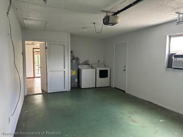 garage featuring water heater, a garage door opener, and washing machine and clothes dryer