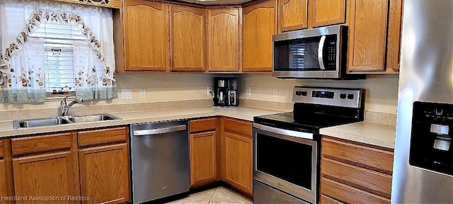 kitchen featuring light tile patterned flooring, stainless steel appliances, and sink