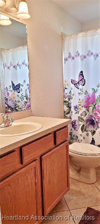 bathroom with tile patterned flooring, vanity, and toilet