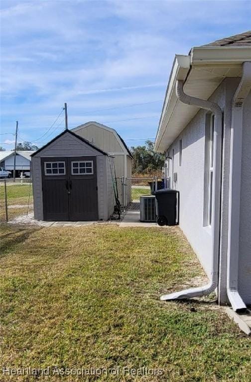 view of yard featuring cooling unit and a storage shed