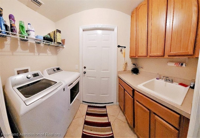 laundry area featuring washer and dryer, sink, light tile patterned floors, and cabinets