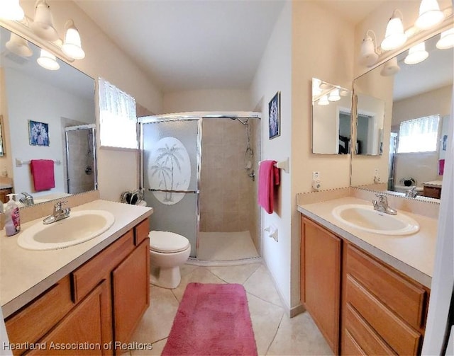 bathroom with a healthy amount of sunlight, an enclosed shower, tile patterned flooring, and vanity