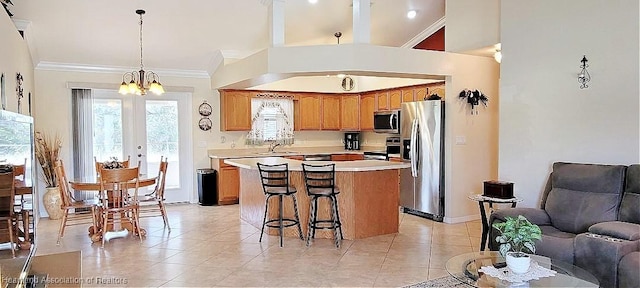 kitchen featuring a kitchen island, decorative light fixtures, sink, ornamental molding, and stainless steel appliances