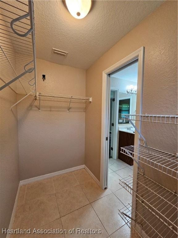 spacious closet with light tile patterned floors and visible vents