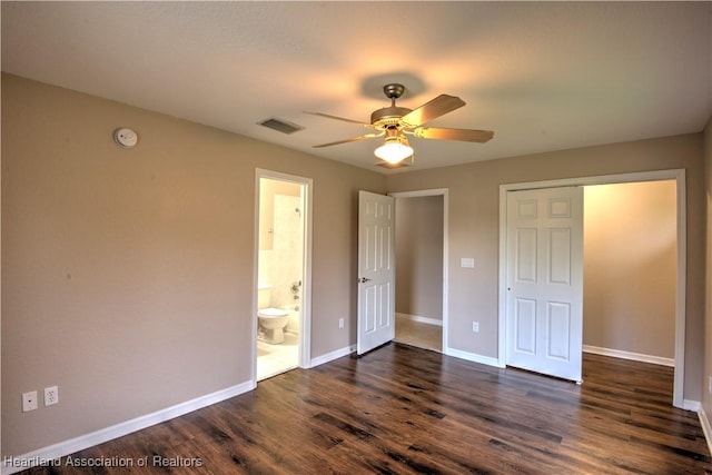 unfurnished bedroom featuring visible vents, a ceiling fan, ensuite bath, dark wood-style floors, and baseboards