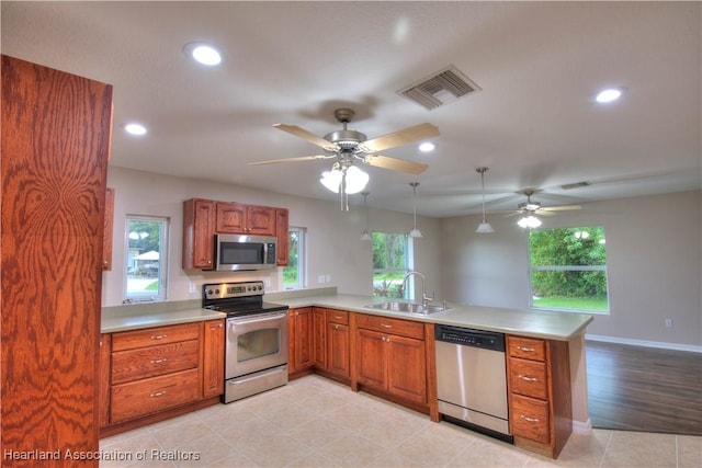 kitchen with visible vents, a sink, stainless steel appliances, a peninsula, and light countertops