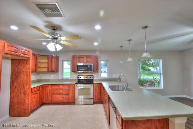 kitchen with visible vents, a sink, appliances with stainless steel finishes, a peninsula, and light countertops