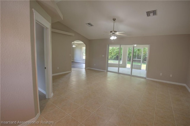 empty room with arched walkways, visible vents, a ceiling fan, and vaulted ceiling