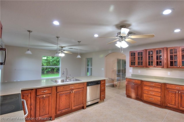 kitchen with arched walkways, a sink, hanging light fixtures, electric stove, and stainless steel dishwasher