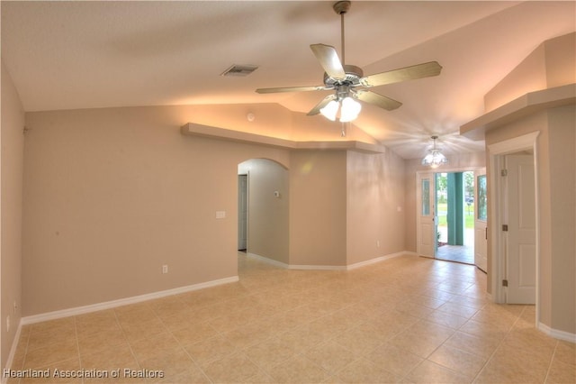 empty room with visible vents, arched walkways, baseboards, ceiling fan, and vaulted ceiling