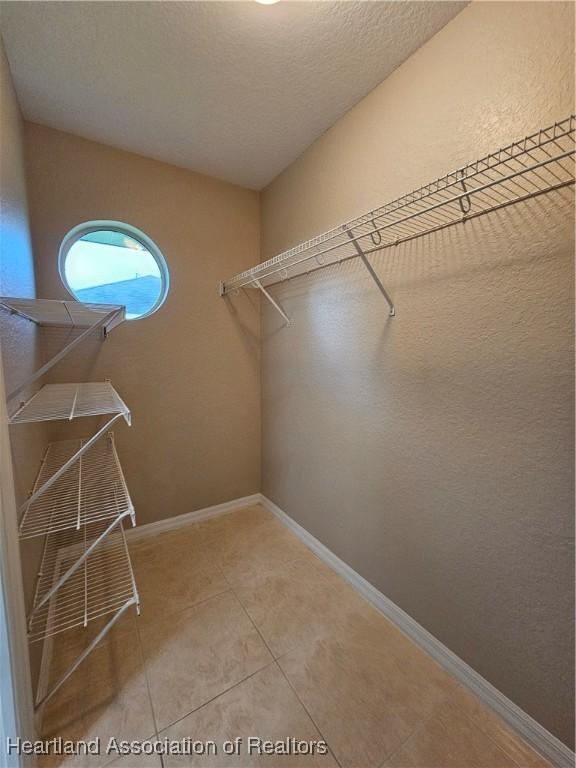 spacious closet featuring tile patterned flooring