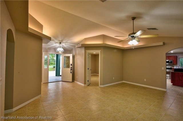 unfurnished room featuring visible vents, baseboards, vaulted ceiling, arched walkways, and a ceiling fan