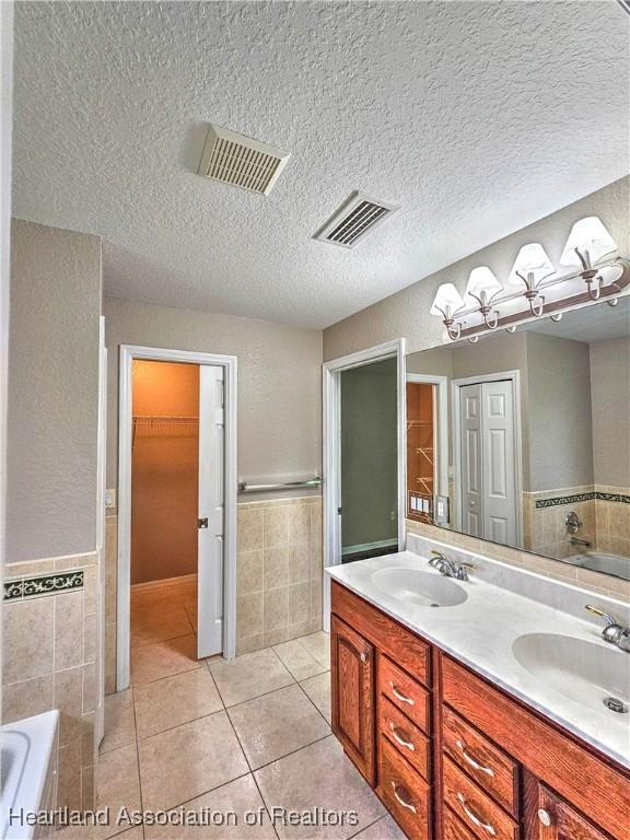 full bath featuring tile patterned floors, visible vents, and a sink