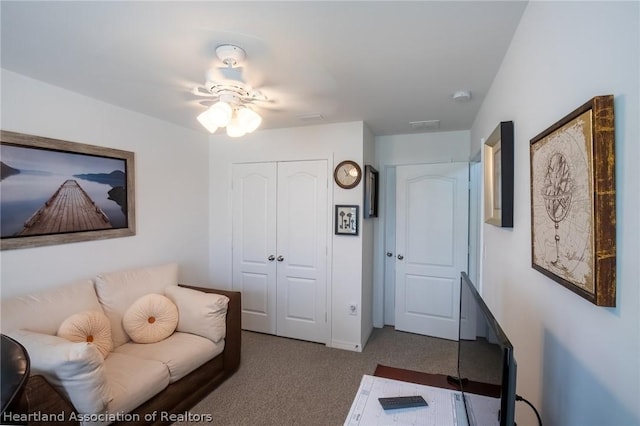 living room featuring dark colored carpet and ceiling fan