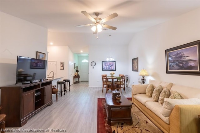 living room with light wood-type flooring, ceiling fan, and lofted ceiling