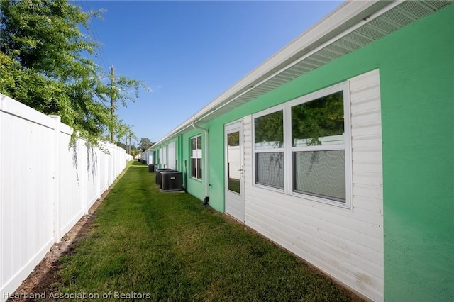 view of home's exterior with a lawn and central air condition unit