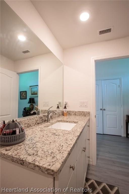 bathroom with vanity and hardwood / wood-style flooring