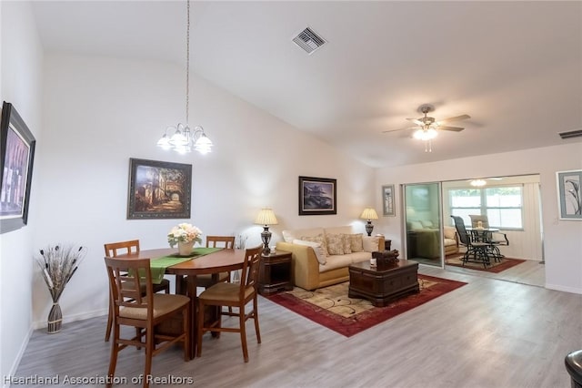 interior space with hardwood / wood-style flooring, ceiling fan with notable chandelier, and lofted ceiling