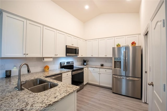 kitchen with white cabinetry, light stone countertops, sink, and appliances with stainless steel finishes