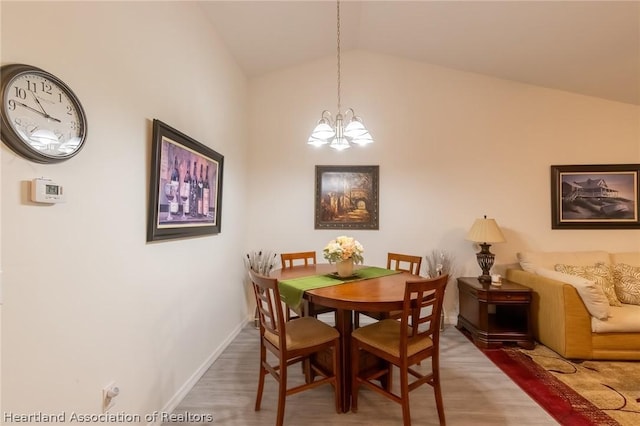 dining space featuring an inviting chandelier and vaulted ceiling