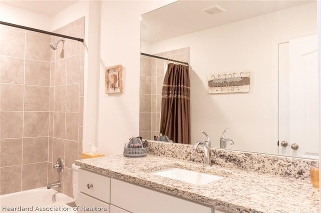 bathroom featuring shower / bathtub combination with curtain and vanity