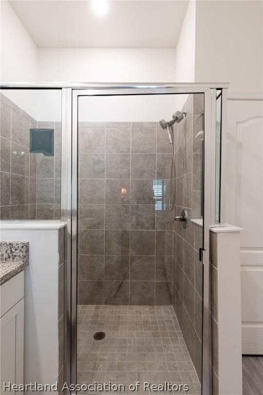 bathroom with vanity and a shower with door