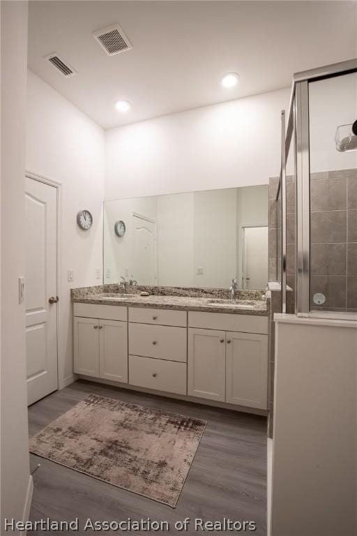 bathroom featuring wood-type flooring, vanity, and walk in shower