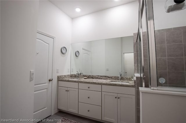 bathroom featuring hardwood / wood-style floors, vanity, and an enclosed shower