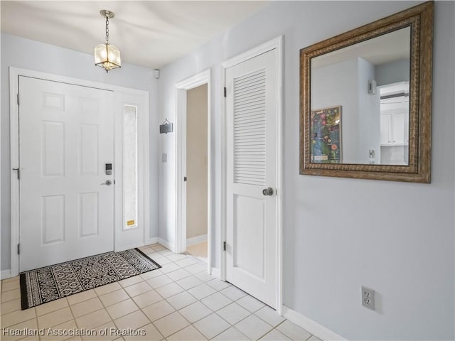 foyer featuring light tile patterned flooring and baseboards