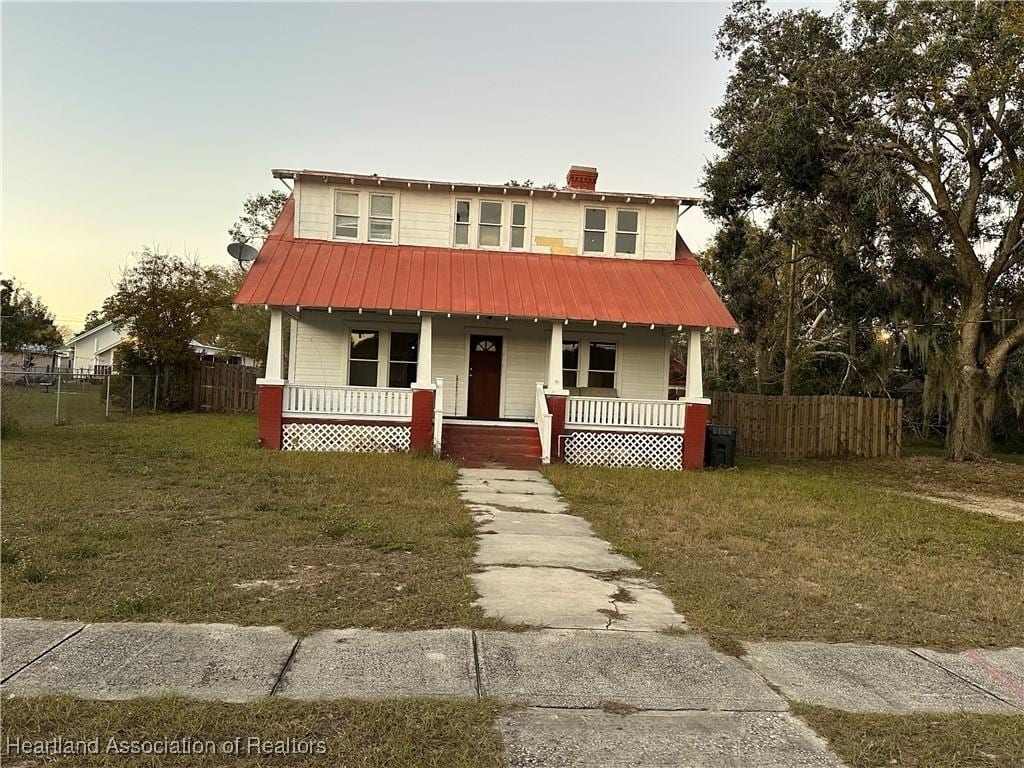 view of front of house with a yard and covered porch