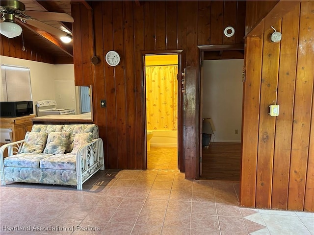11 Mockingbird Rd, Lake Placid, FL 33852 - living area with wood walls, ceiling fan, light tile patterned floors, washer / dryer, and lofted ceiling