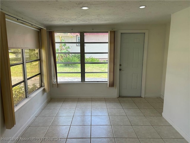 11 Mockingbird Rd, Lake Placid, FL 33852 - empty room with light tile patterned floors, plenty of natural light, a textured ceiling, and recessed lighting