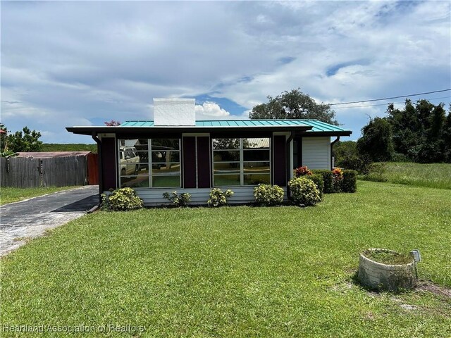11 Mockingbird Rd, Lake Placid, FL 33852 - view of front of house featuring a standing seam roof, a chimney, and a metal roof