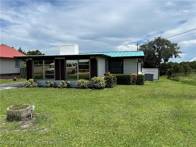11 Mockingbird Rd, Lake Placid, FL 33852 - view of front of home featuring a chimney, a front lawn, a metal roof, and a standing seam roof