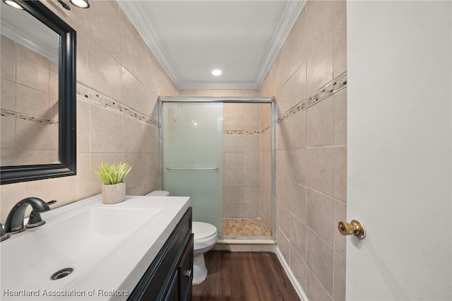 bathroom featuring hardwood / wood-style floors, an enclosed shower, tile walls, and ornamental molding