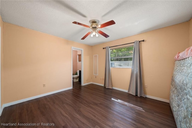 unfurnished bedroom featuring a textured ceiling, ensuite bath, ceiling fan, and dark wood-type flooring