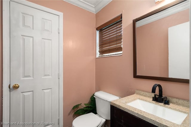 bathroom featuring toilet, vanity, and ornamental molding