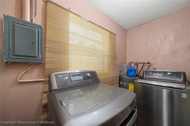 laundry area featuring separate washer and dryer, a textured ceiling, and electric panel