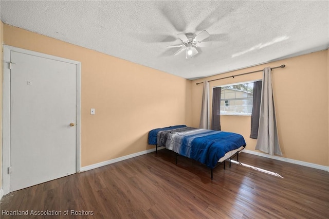 bedroom featuring hardwood / wood-style floors, ceiling fan, and a textured ceiling